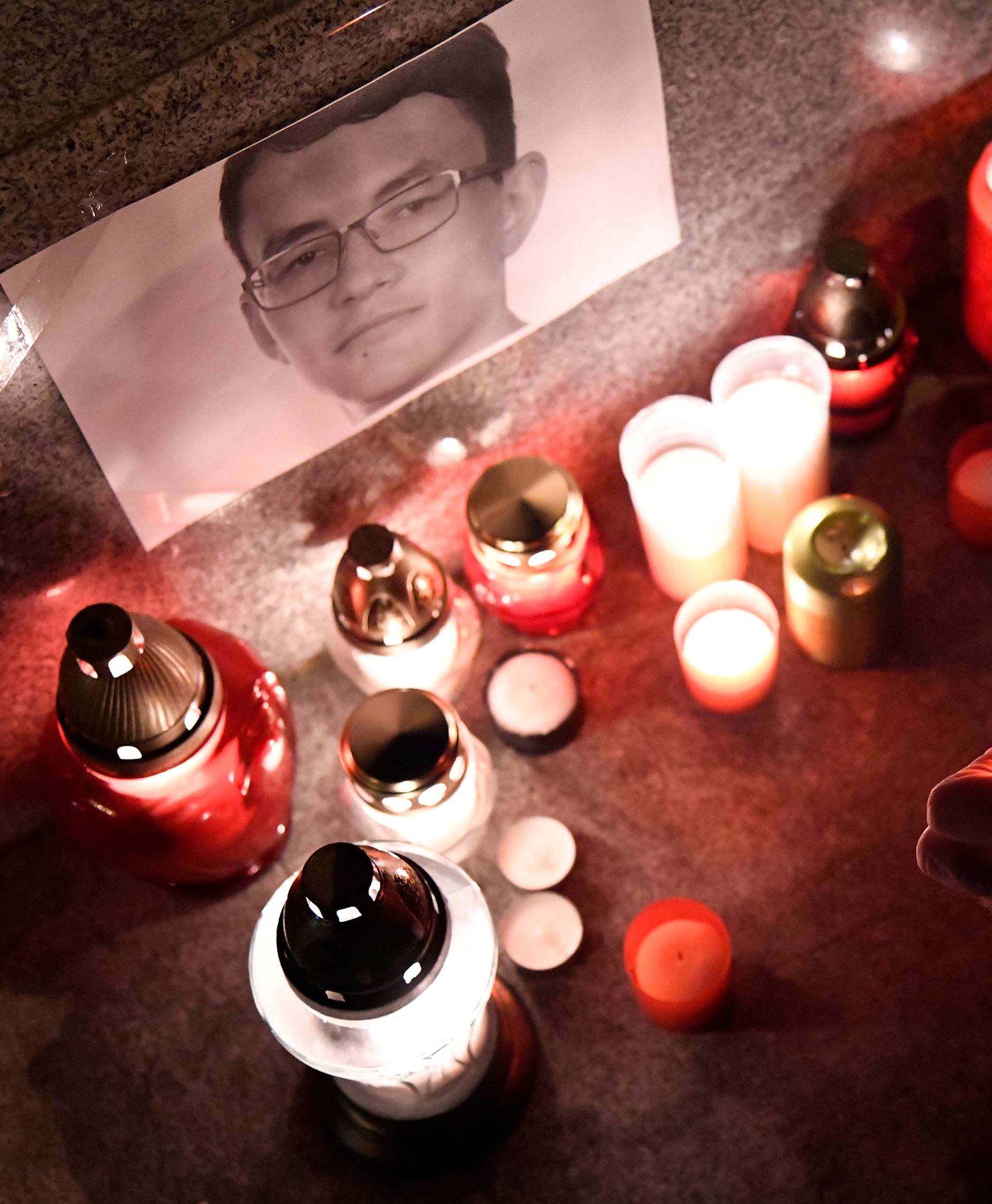 A journalist lights a candle in memory of murdered investigative journalist Jan Kuciak, in Trencin