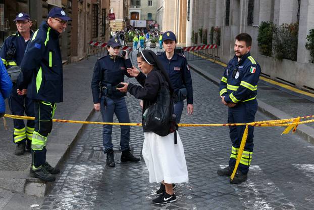 A nun reacts as she is denied entry by police to a side street near the Vatican following the death of Pope Francis, in Rome