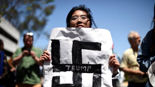 Carla Espinosa holds a protest sign against presidential candidate Donald Trump outside the California Republican Party convention in Burlingame