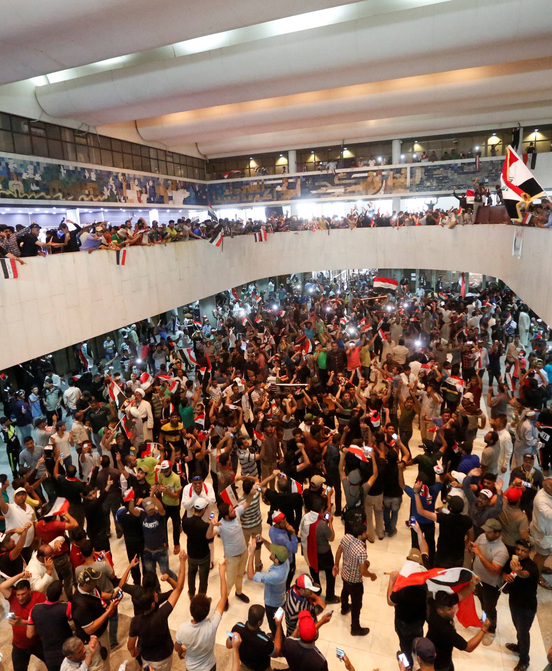 Followers of Iraq's Shi'ite cleric Moqtada al-Sadr are seen in the parliament building as they storm Baghdad's Green Zone after lawmakers failed to convene for a vote on overhauling the government, in Iraq