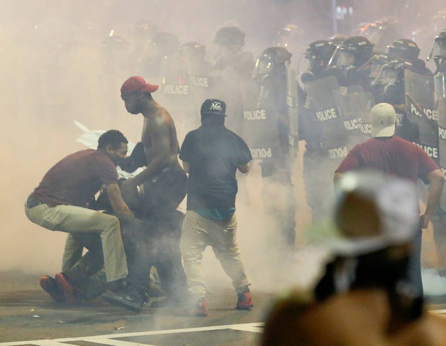 People maneuver amongst tear gas in uptown Charlotte, NC during a protest of the police shooting of Keith Scott, in Charlotte