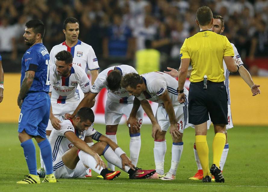 Olympique Lyon's player look at injured team mate Maxime Gonalons during match against Dinamo Zagreb
