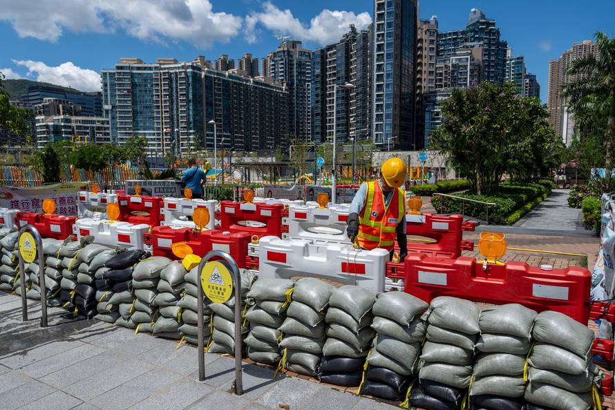 A worker filling barricade with water next to sandbags at Tseung Kwan O District to prepare for Typhoon Ragasa on September 22, 2025 in Hong Kong. (Photo by Vernon Yuen/Nexpher Images)