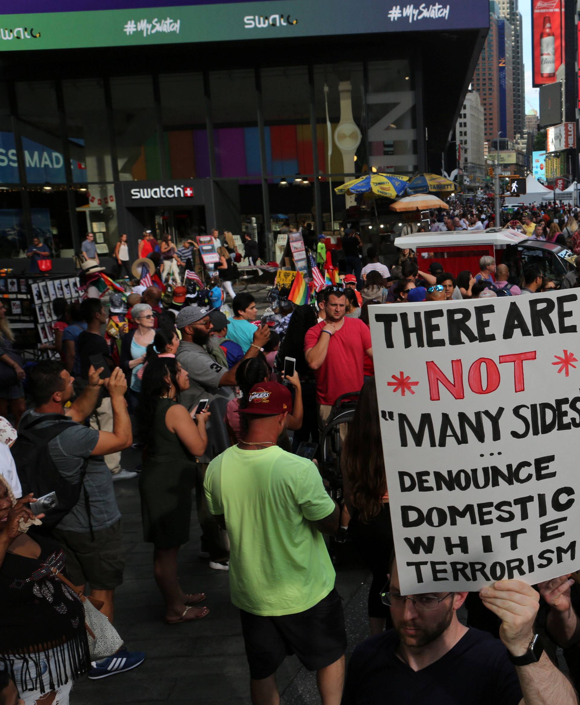 A protester holds a sign reading "There are not "many sides", Denounce domestic white terrorism" at a march against white nationalism in Times Square in New York City