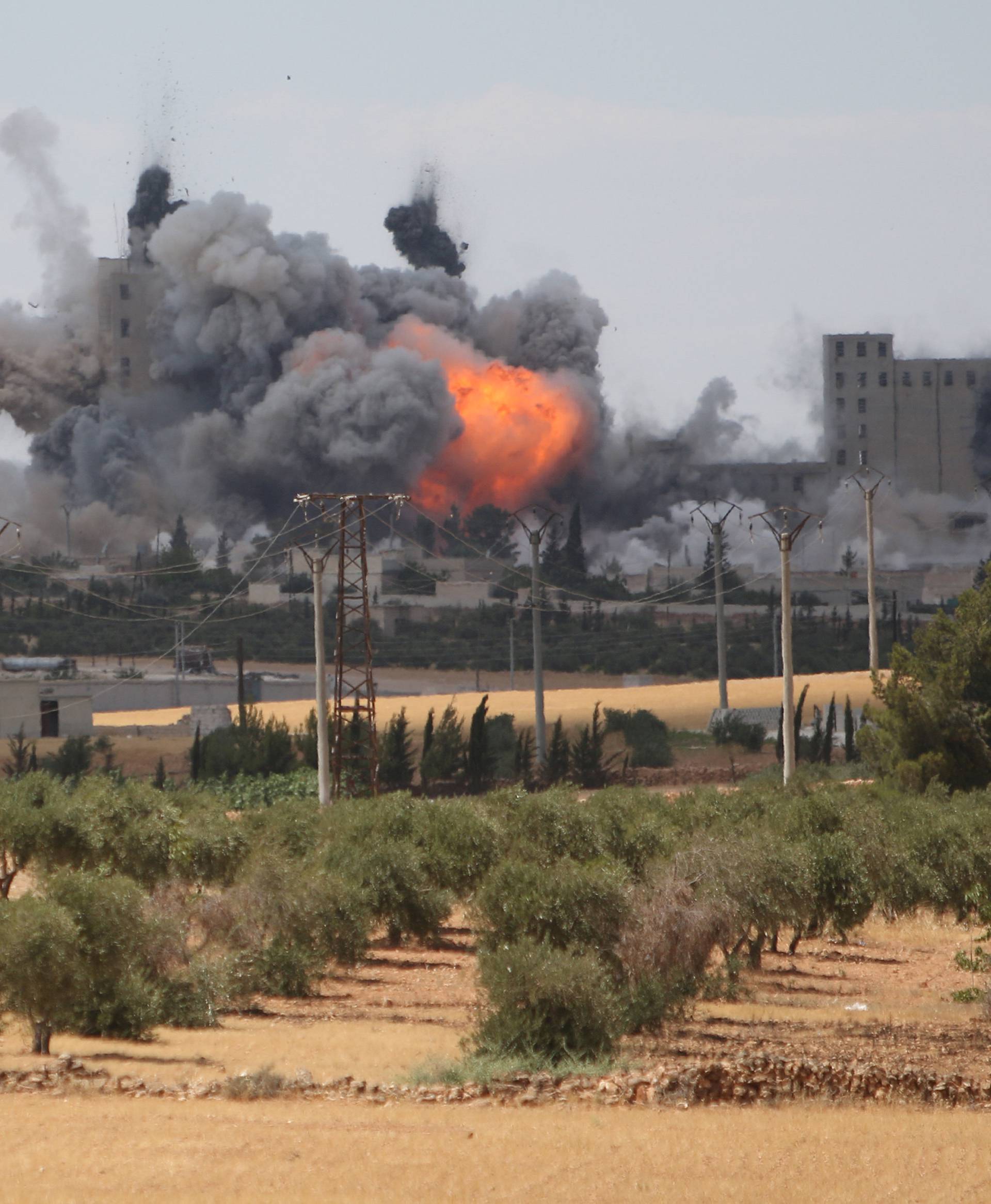 Smoke and flame rise after what fighters of the Syria Democratic Forces (SDF) said were U.S.-led air strikes on the mills of Manbij where Islamic State militants are positioned,  in Aleppo Governorate