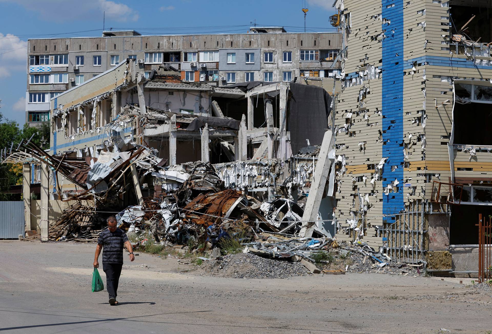 A man walks past a destroyed building in Mariupol