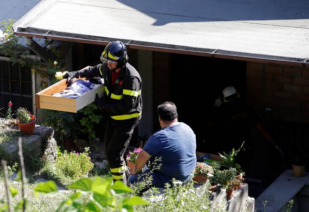 A firefighter takes out belongings from a man