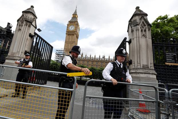 Armed police officers secure the Carriage Gate entrance as they stand outside the Palace of Westminster, in central London