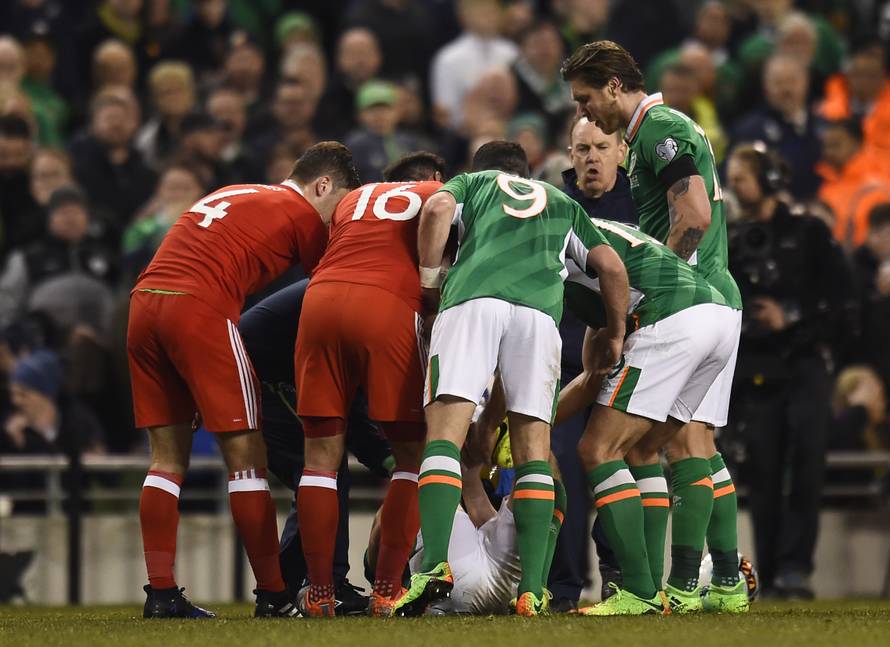 Players surround Republic of Ireland's Seamus Coleman as he lies injured