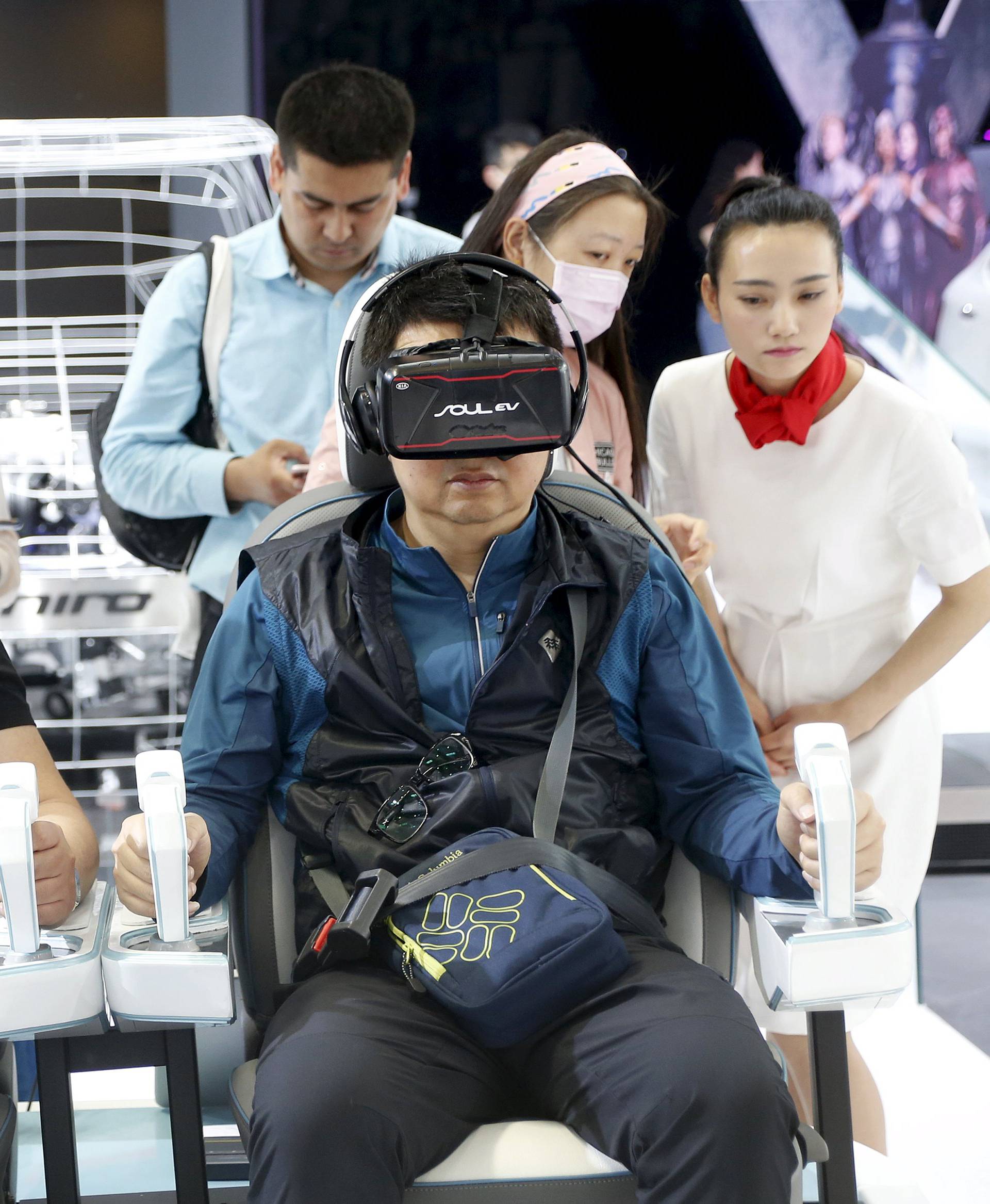 Visitor use VR experience technology at the booth of Kia Motors during the Auto China 2016 auto show in Beijing