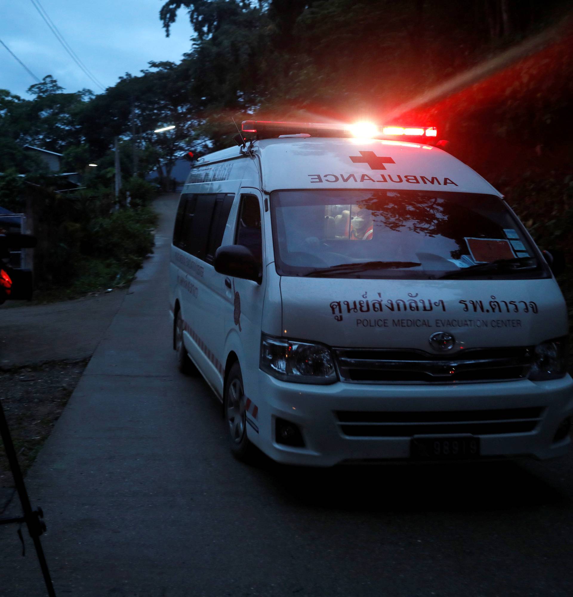 Journalists film an ambulance believed to be carrying rescued schoolboys as it travels to a military helipad near Tham Luang cave complex in the northern province of Chiang Rai
