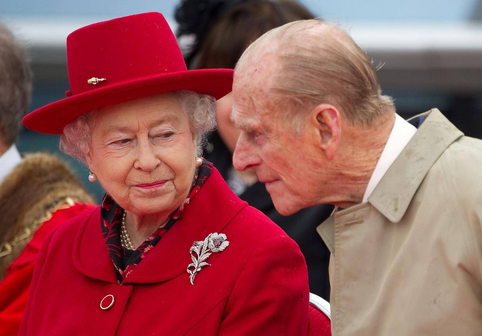 FILE PHOTO: Britain's Queen Elizabeth speaks to her husband Prince Philip as they attend the official re-opening of the Cutty Sark in Greenwich, London