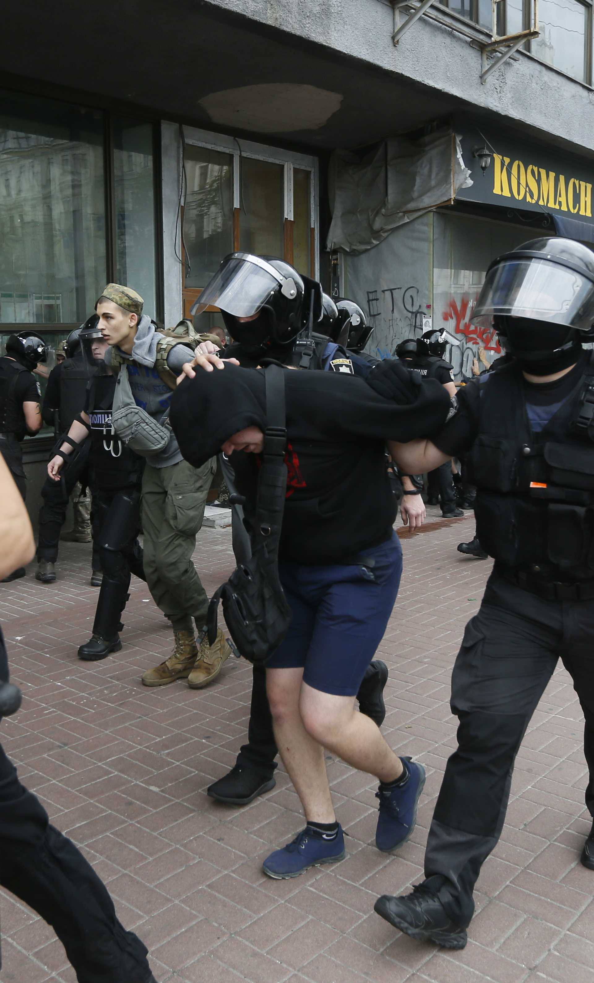 Riot police officers detain anti-LGBT protesters during the Equality March in Kiev