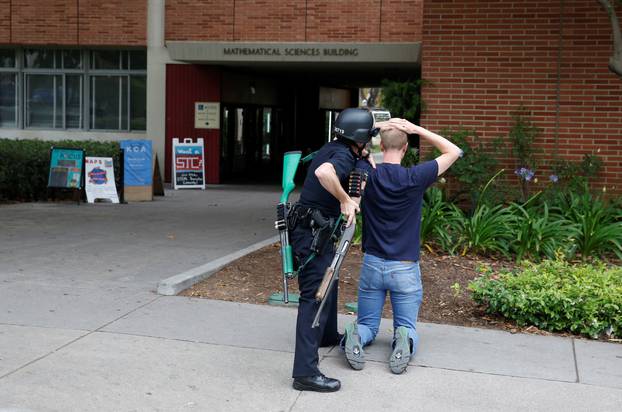 A police officer searches a student at the University of California, Los Angeles campus after it was placed on lockdown following reports of a shooter on the campus in Los Angeles