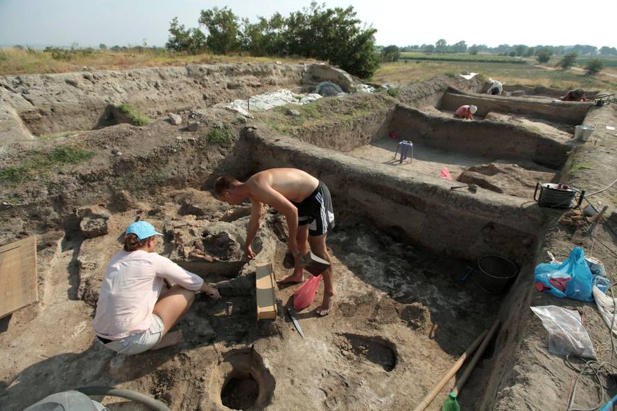 Bulgarian archaeologists dig during excavation works in an ancient settlement near the village of Yunatsite
