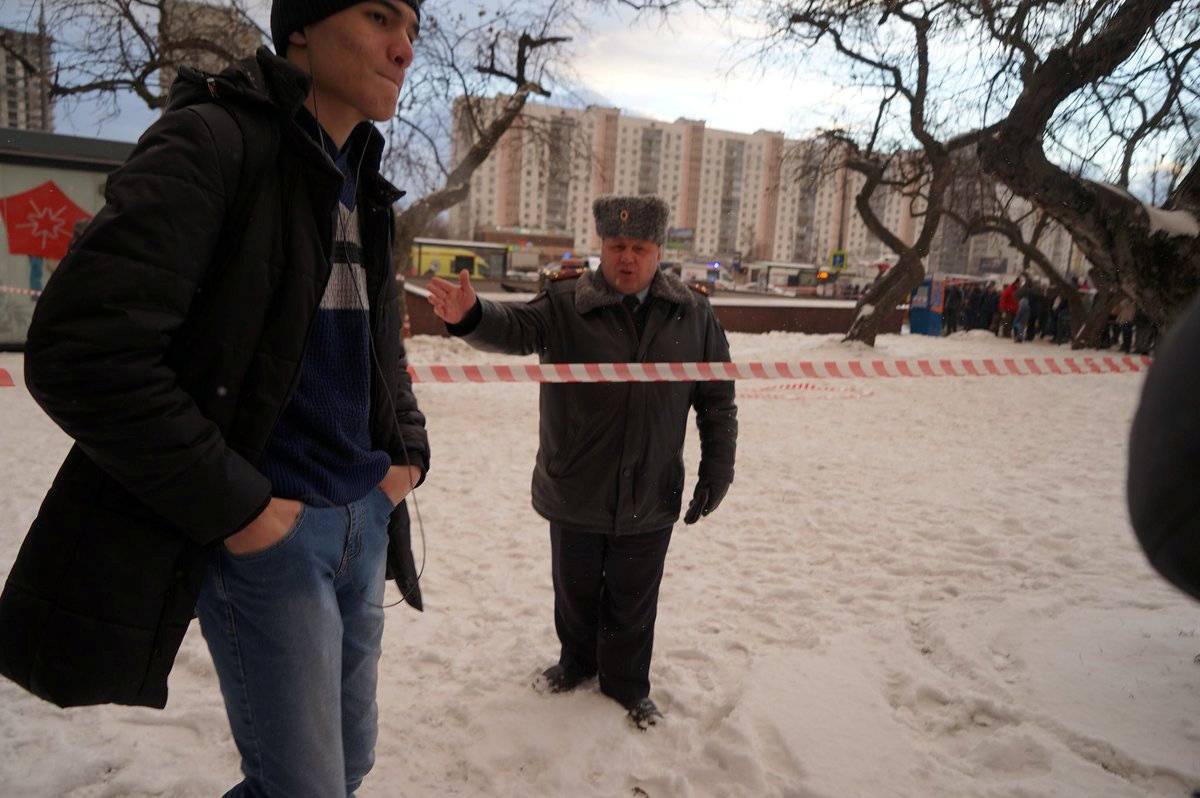 A police officer gestures at a cordoned off area following a crash involving a passenger bus in Moscow