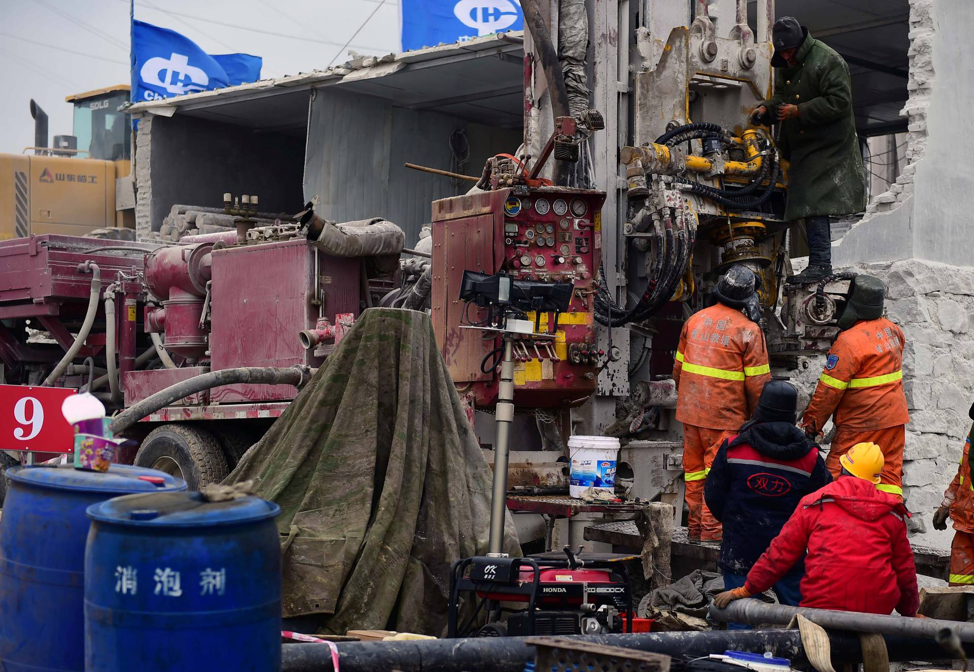 Rescuers work on saving workers trapped underground after an explosion at the Hushan gold mine in Qixia