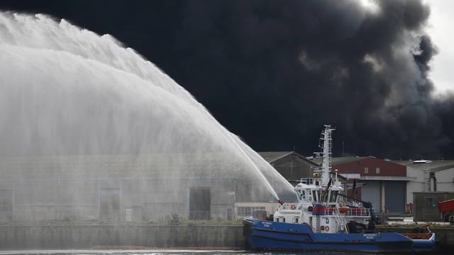 Firefighting vessel sprays water after a large fire broke out at the factory of Lubrizol in Rouen