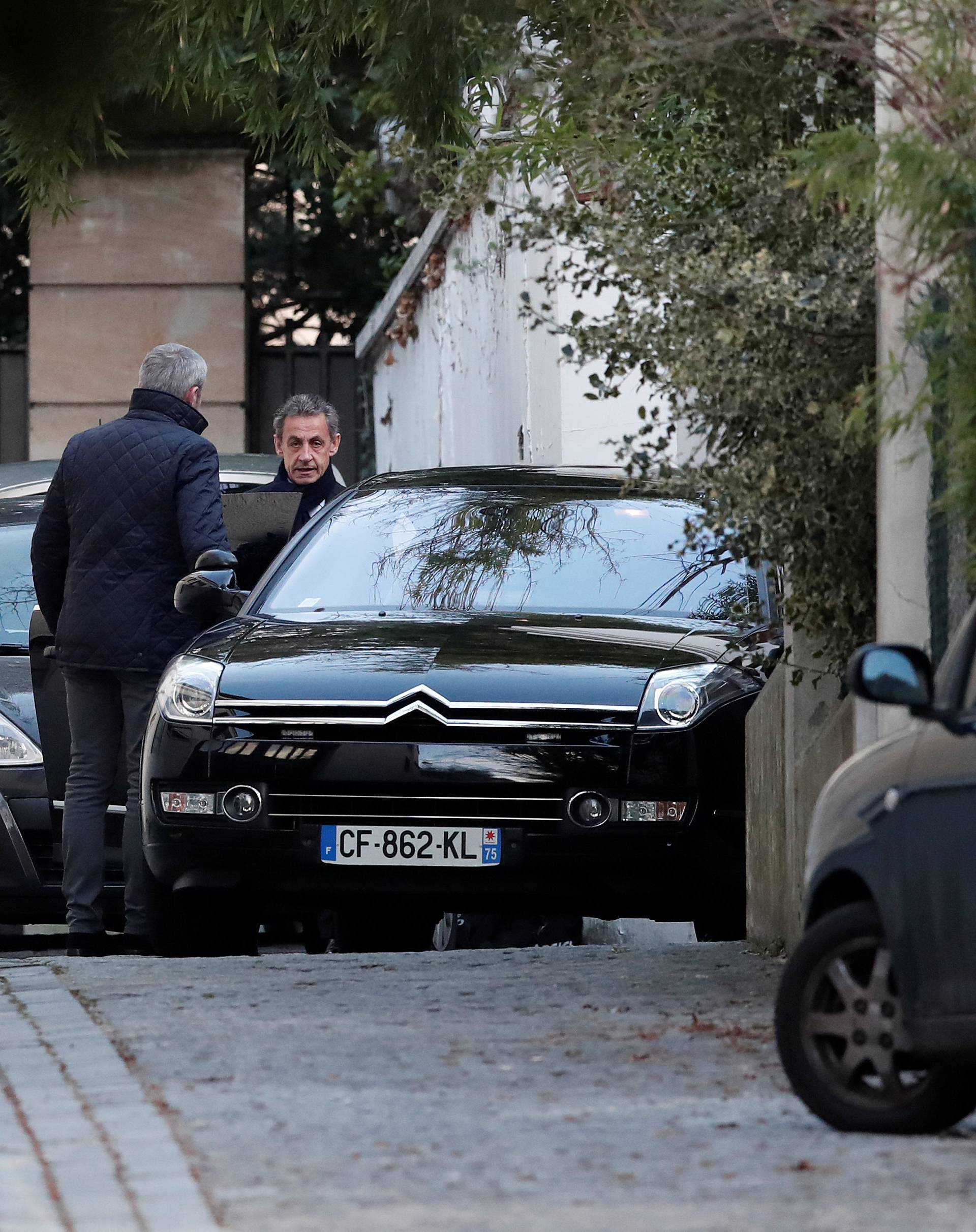 Former French President Nicolas Sarkozy enters his car as he leaves his house in Paris