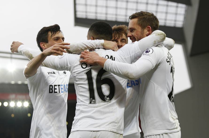 Swansea City's Gylfi Sigurdsson celebrates scoring their third goal with teammates