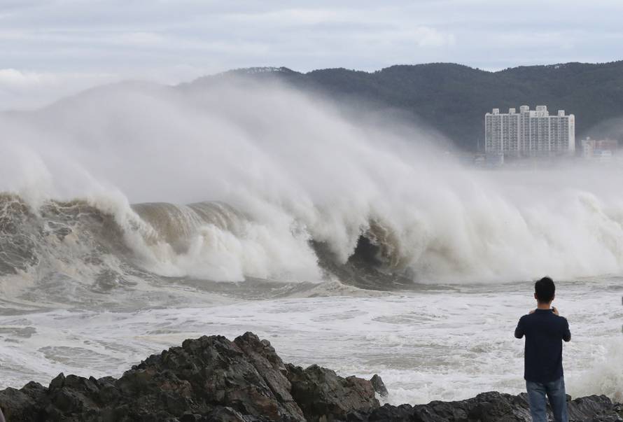 A man looks at a high wave caused by Typhoon Hinnamnor in Ulsan