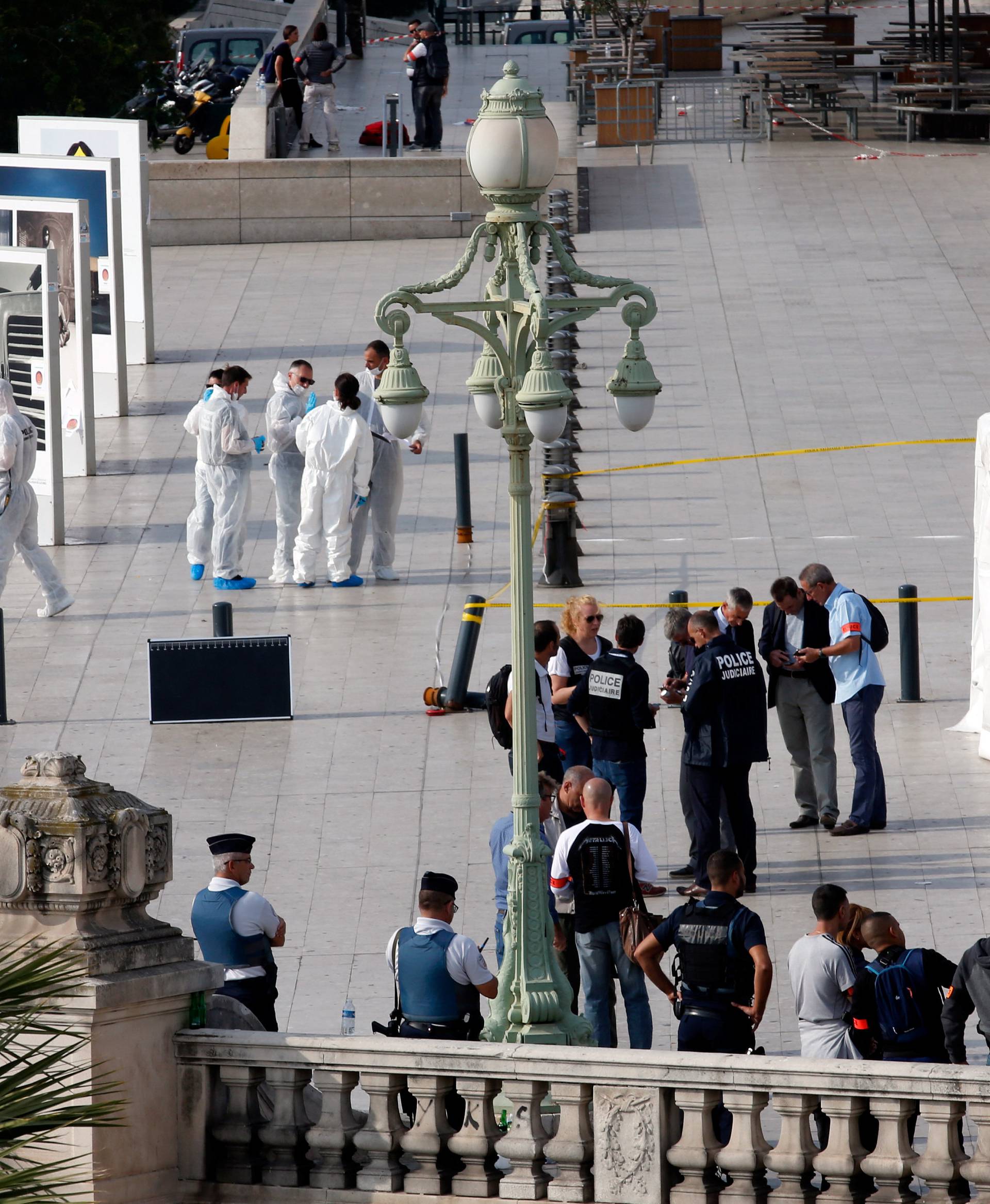 Police investigators work outside the Saint-Charles train station after French soldiers shot and killed a man who stabbed two women to death at the main train station in Marseille