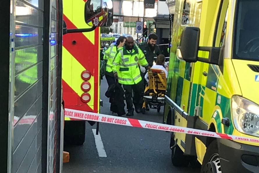 Emergency personnel attend to a person after an incident at Parsons Green underground station in London