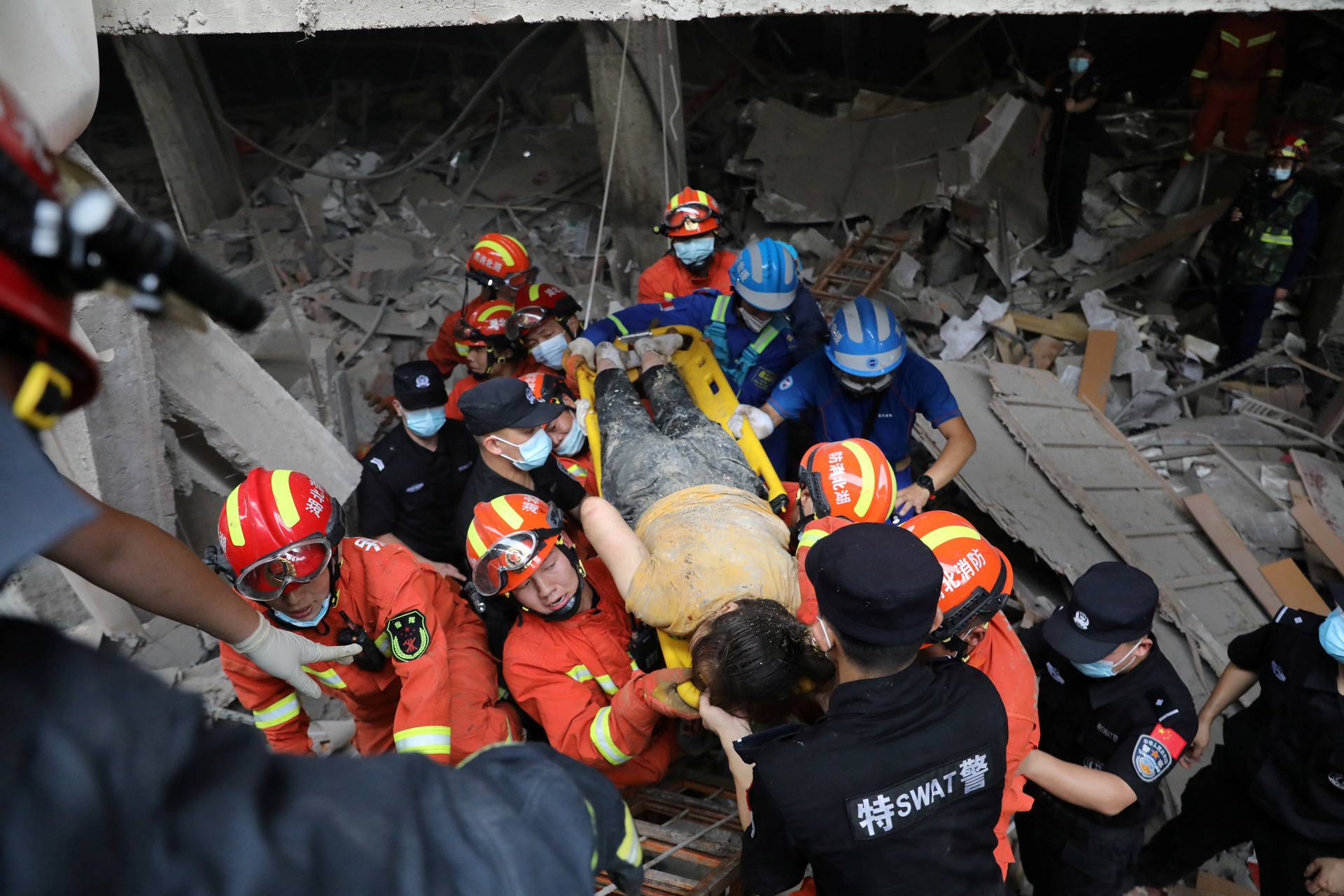 Rescue workers carry an injured woman on a stretcher following a gas pipeline explosion in Shiyan