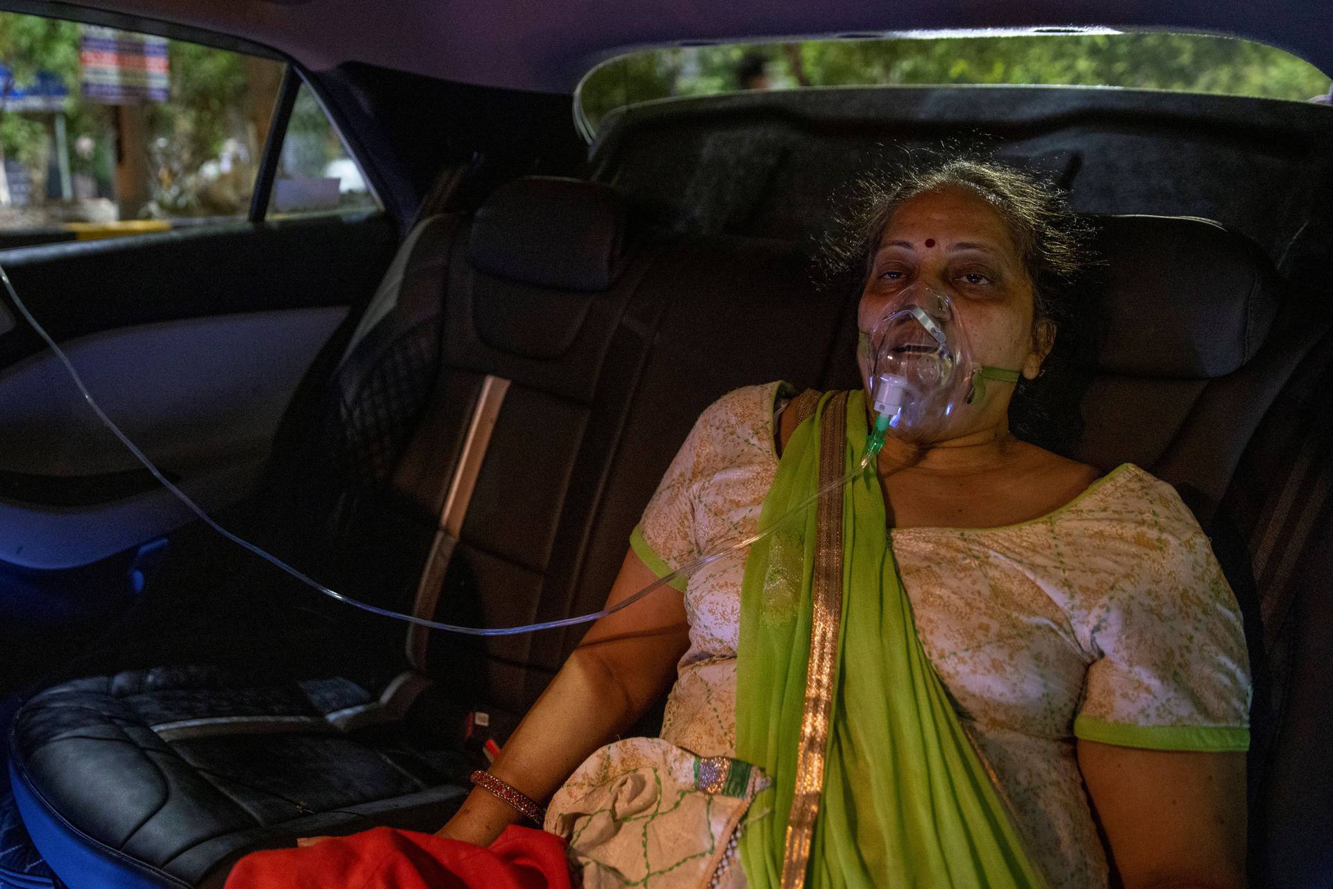 A woman with a breathing problem receives oxygen support for free inside her car at a Gurudwara, in Ghaziabad