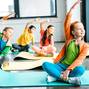 Happy kids stretching on fitness mats with smile