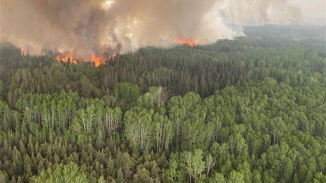 Smoke rises from the Paskwa Wildfire (HLW030) as it burns near the Wood Buffalo National Park boundary