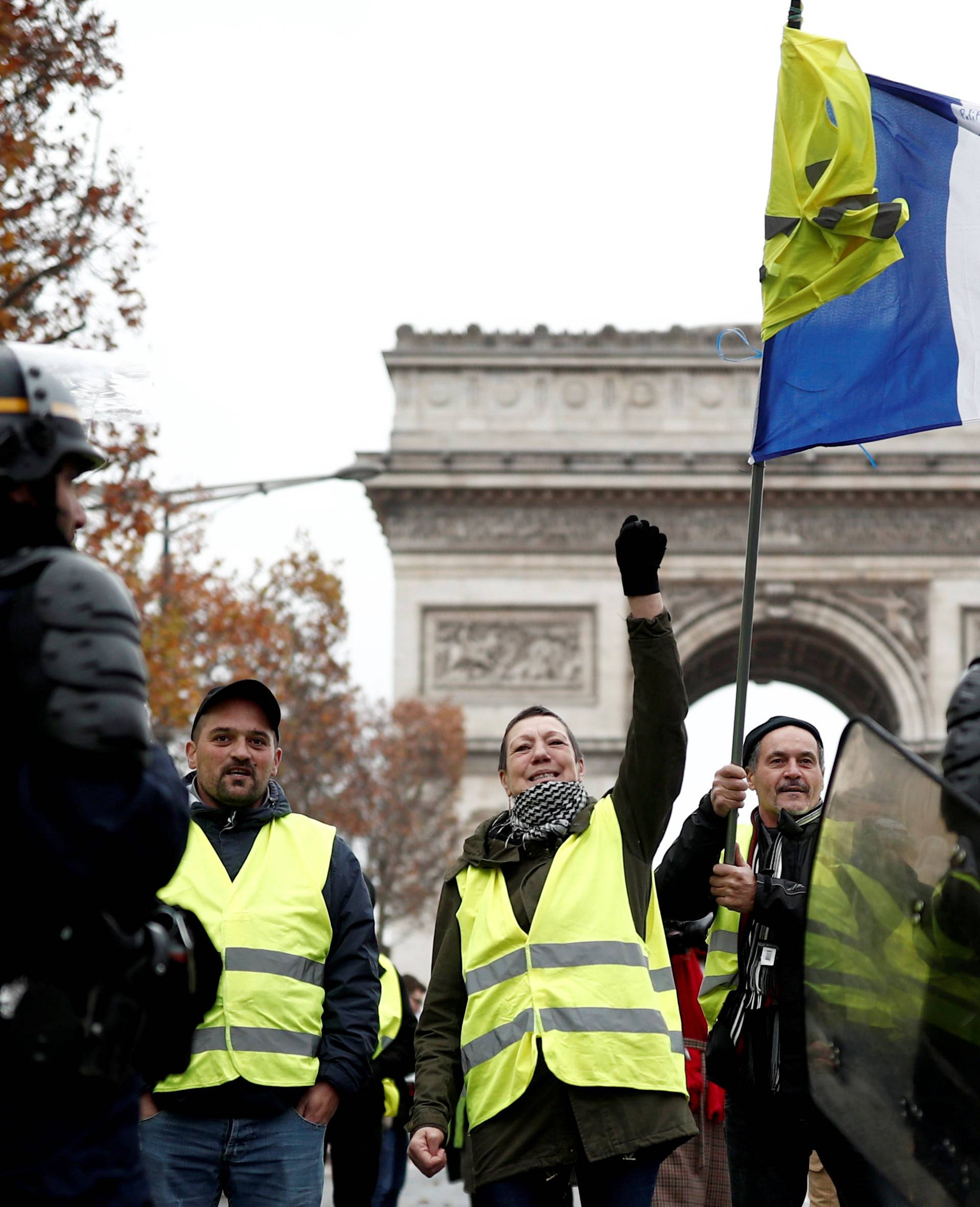 Protesters wearing yellow vests, a symbol of a French drivers' shout out slogans during protest against higher fuel prices, block the street in Paris