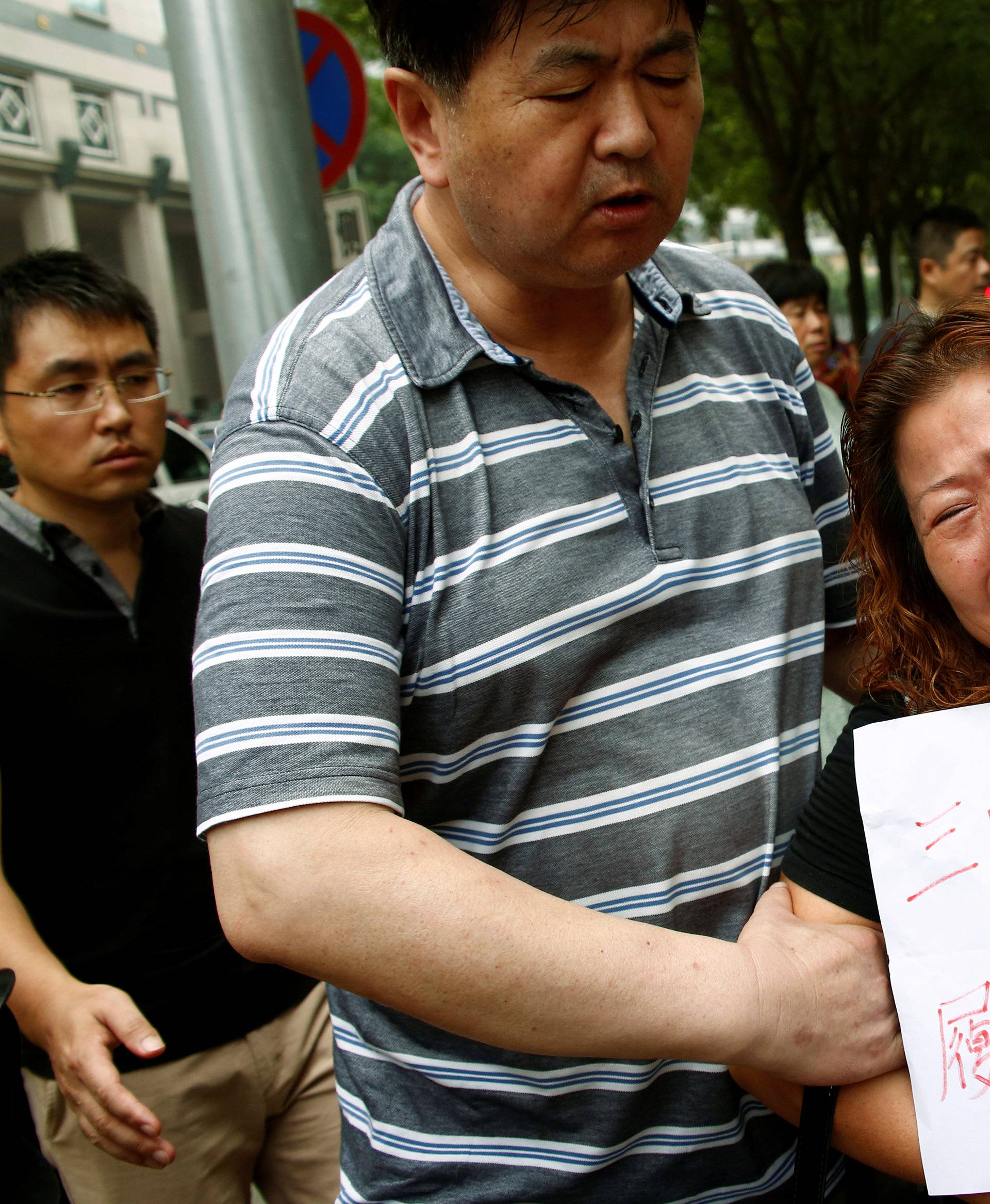 A family member of a passenger aboard Malaysia Airlines flight MH370 which went missing in 2014 reacts during a protest outside the Chinese foreign ministry in Beijing