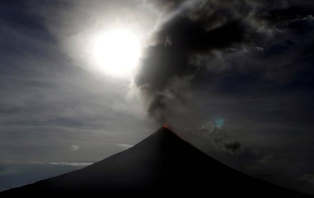 The super blue moon rises above the spewing Mayon Volcano during a mild eruption before a total lunar eclipse in Legazpi