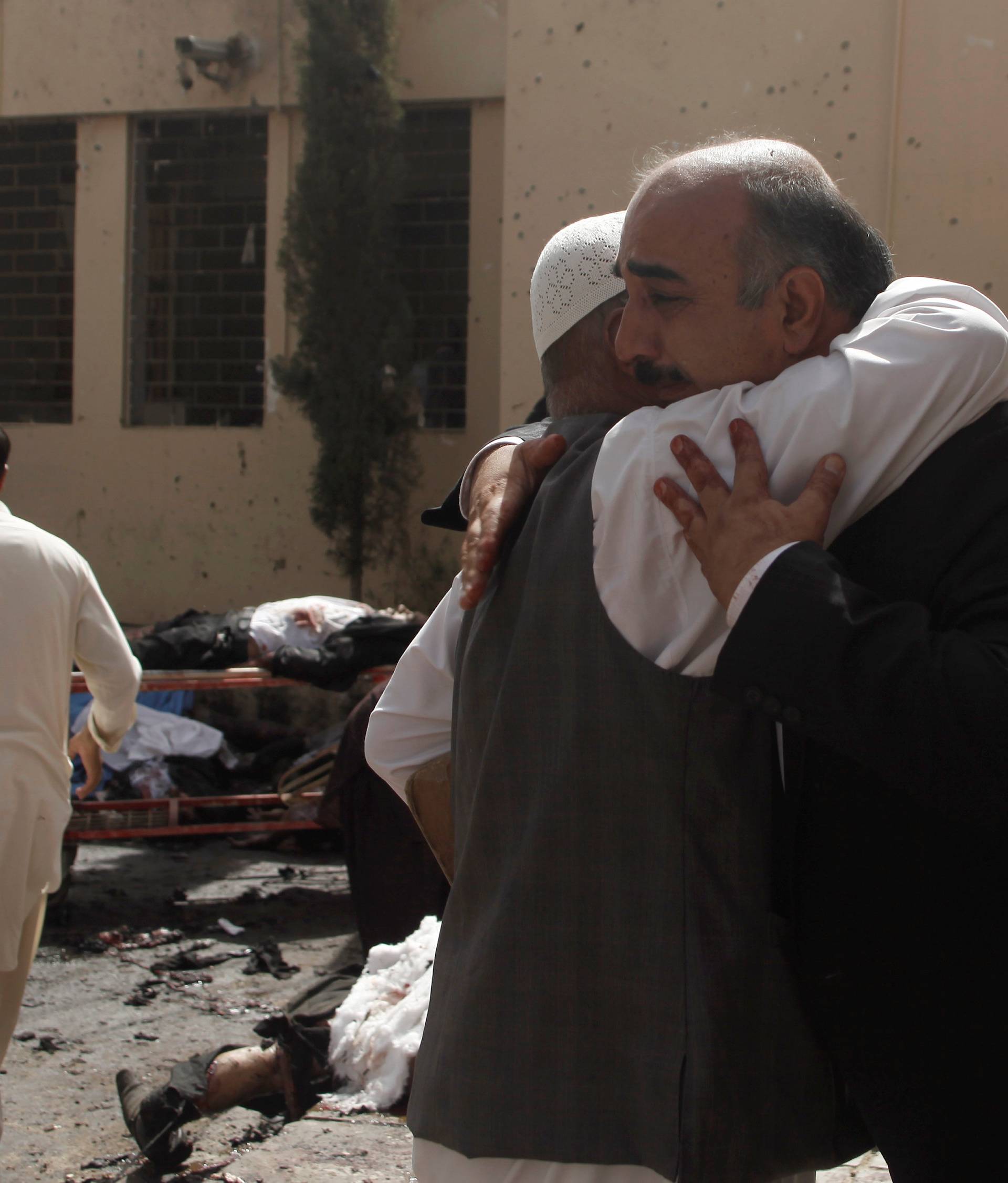 People grieve at the scene of a bomb blast outside a hospital in Quetta