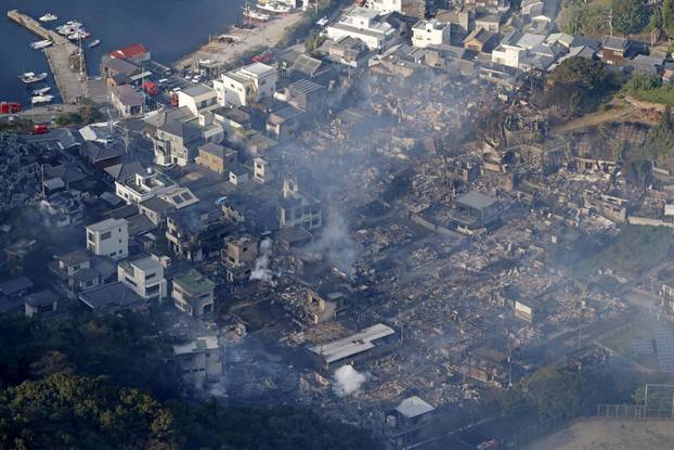 Smoke rises from a site where a massive fire blazed through more than 170 buildings, as seen from a helicopter, in Oita