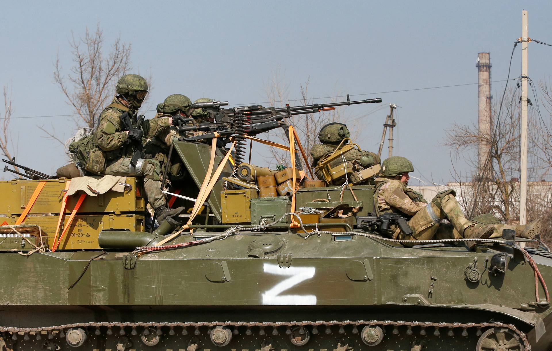 Service members of pro-Russian troops are seen atop of an armoured vehicle in the besieged city of Mariupol