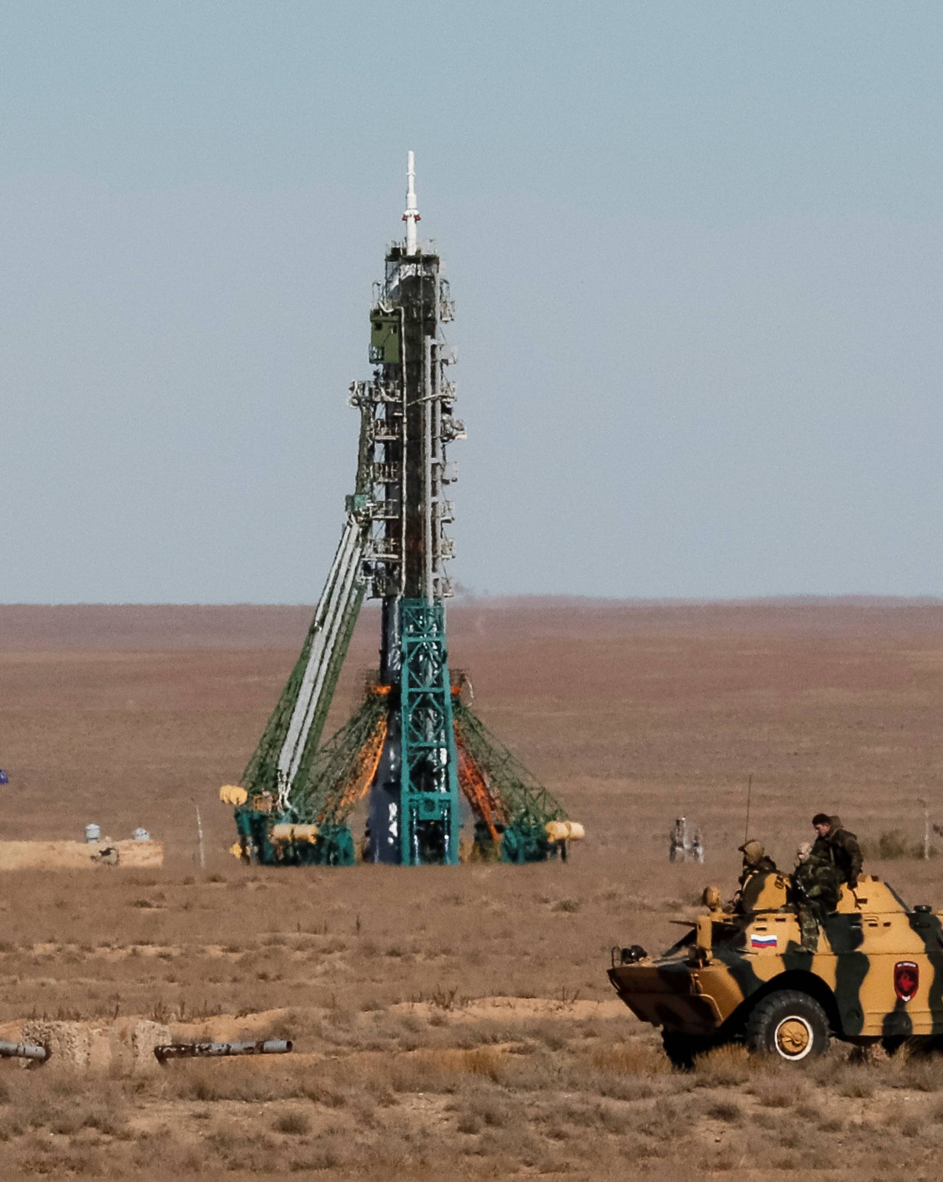 Security personnel drive an armored vehicle past the Soyuz MS-10 spacecraft with the crew of astronaut Nick Hague of the U.S. and cosmonaut Alexey Ovchinin of Russia, shortly before its launch to the International Space Station (ISS) from the launchpad at