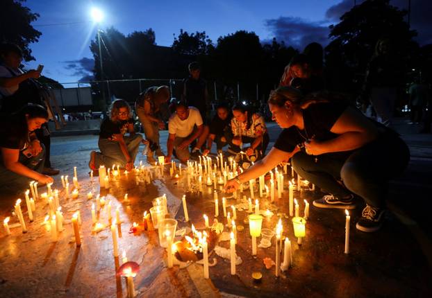 People light candles as they attend a vigil outside the Nuestra Senora de los Dolores church to pray for victims of earthquakes, in Valencia