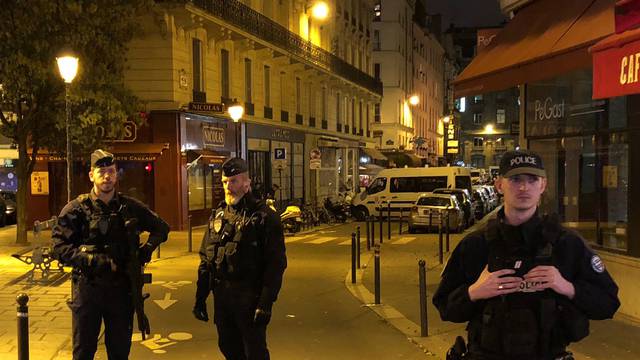 French police secure a street after a man killed a passer-by in a knife attack in the heart of Paris and injured four others before being shot dead by police