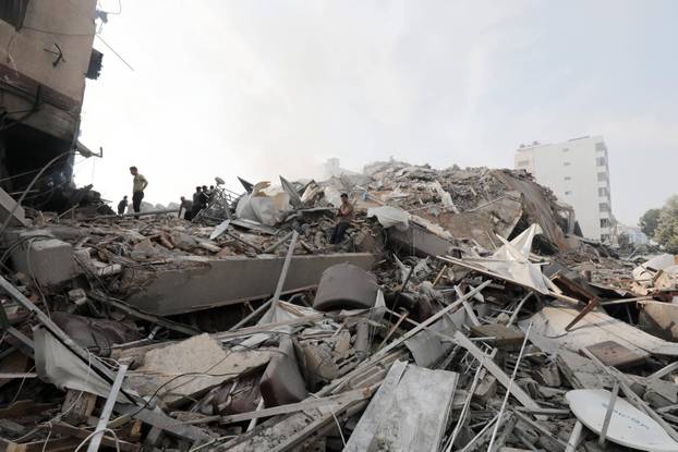 Palestinians inspect the ruins of Watan Tower destroyed in Israeli airstrikes Palestinians inspect the ruins of Watan To