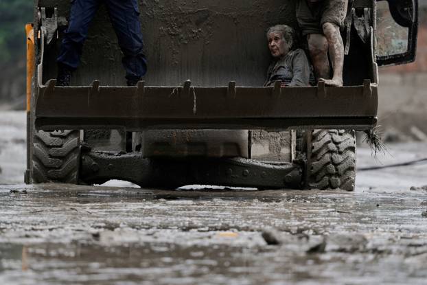 A survivor is transported to a safer place in heavy machinery following a flash flood at Trishuli, Nepal