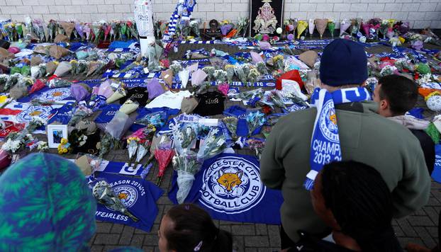 Leicester City football fans pay their respects outside the football stadium, after the helicopter of the club owner Thai businessman Vichai Srivaddhanaprabha crashed when leaving the ground on Saturday evening after the match, in Leicester