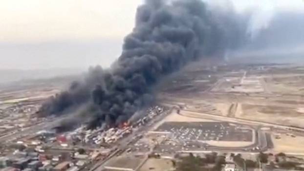 An aerial view shows plumes of thick black smoke rising, following a suspected explosion of chemical materials