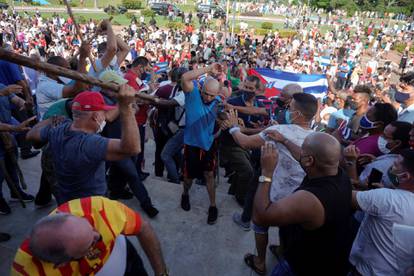 People clash with plain clothes police during protests against and in support of the government, in Havana