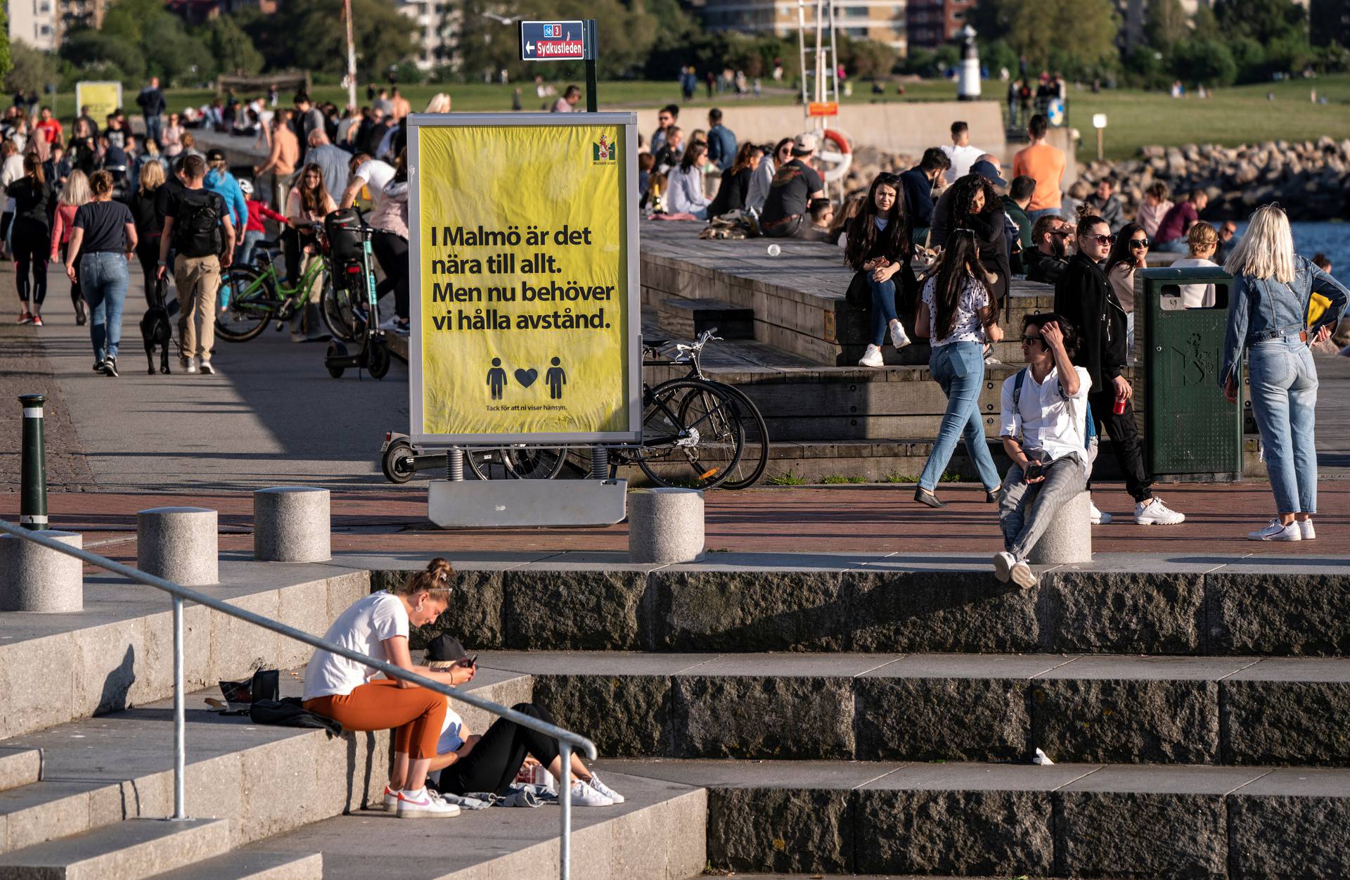 People enjoy the warm evening at Sundspromenaden in Malmo