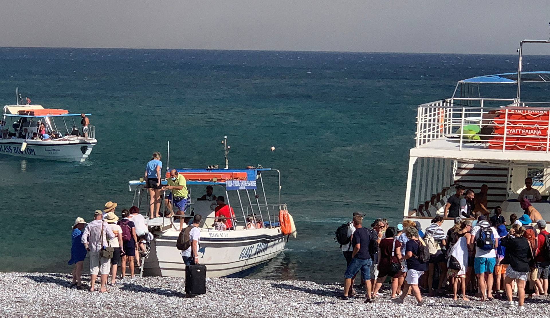 Tourists are being evacuated as wildfire burns near Lindos on the island of Rhodes