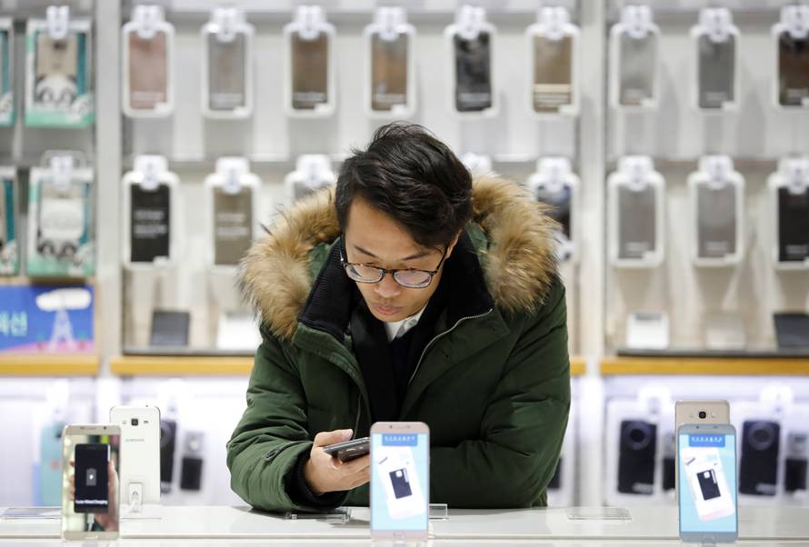 A man tries out a Samsung Electronics' smartphone at its store in Seoul