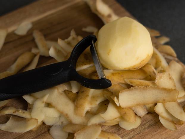 raw potatoes with peeled skin on the wooden desk on the table