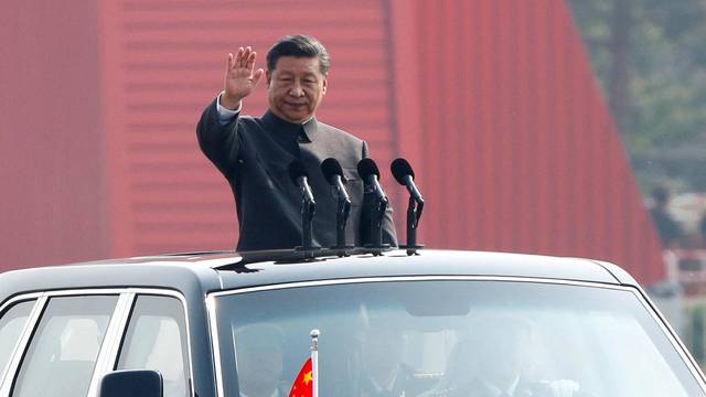 FILE PHOTO: Chinese President Xi Jinping waves from a vehicle as he reviews the troops at a military parade marking the 70th founding anniversary of People's Republic of China